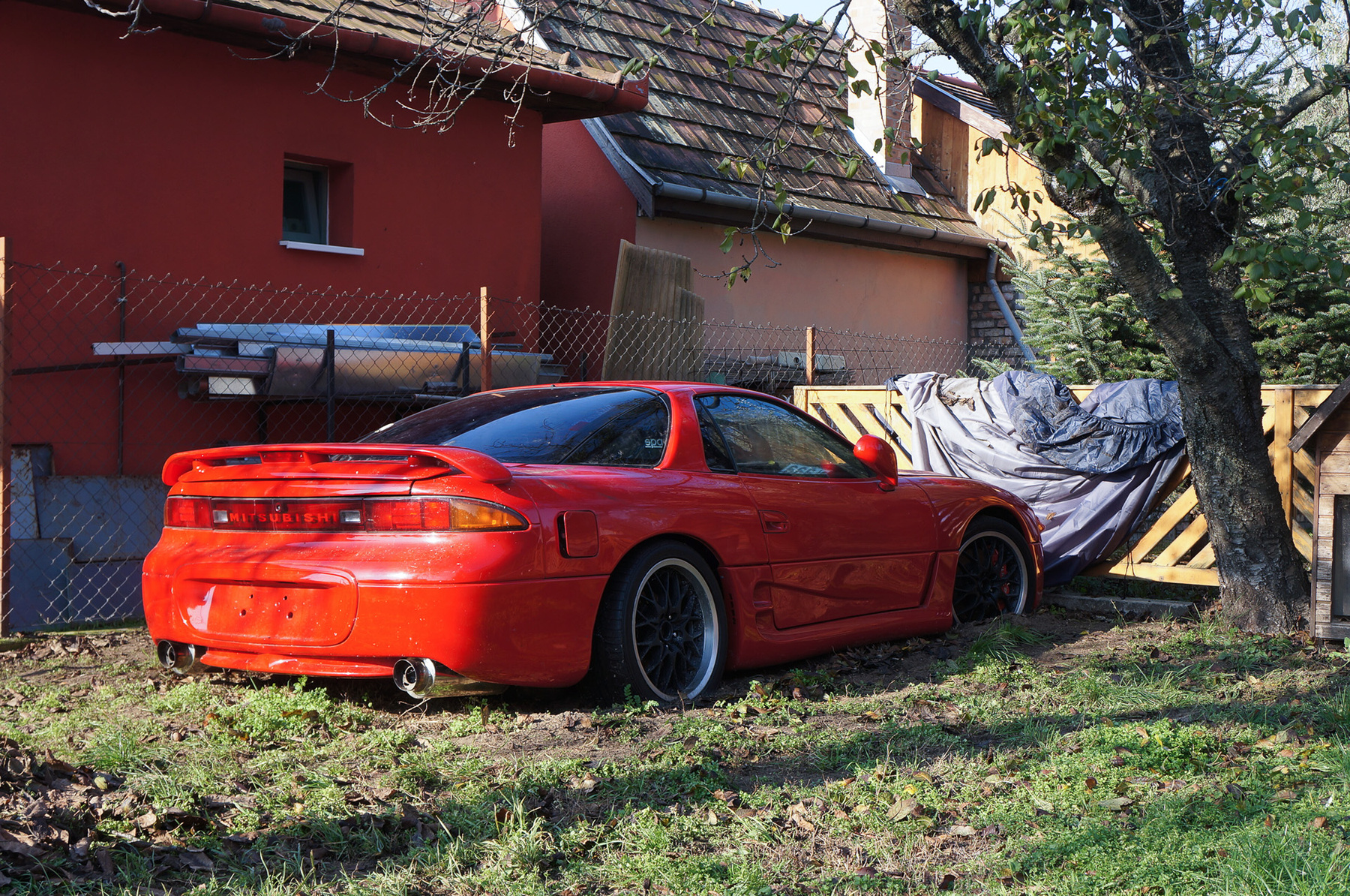 Egy másik, szerelés alatt álló autó, egy Maserati áll kint a műhely udvarán. Hátsó oldalablaka hiányzik, az utastérben bedobált alkatrészek láthatók. Ezt a fotót Márk készítette, amikor elment megnézni saját autóját Lászlóhoz