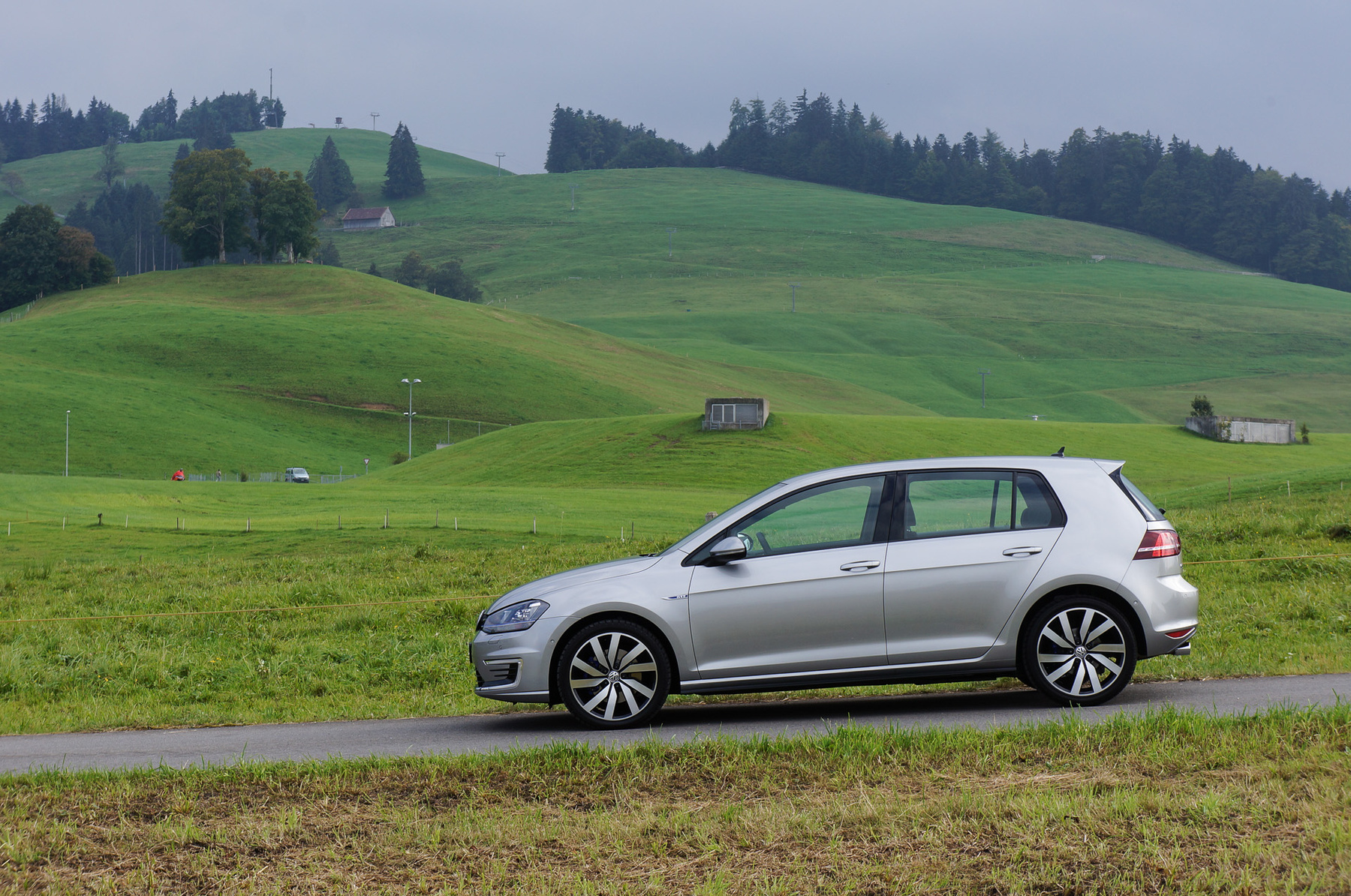 A kékes hátterű Volkswagen embléma-ajtó mögött találjuk a töltőcsatlakozót. A kábelt reteszelés védi a lopástól. A kábel hossza néhány méter csupán, hagyományos hosszabbítóval nem használható